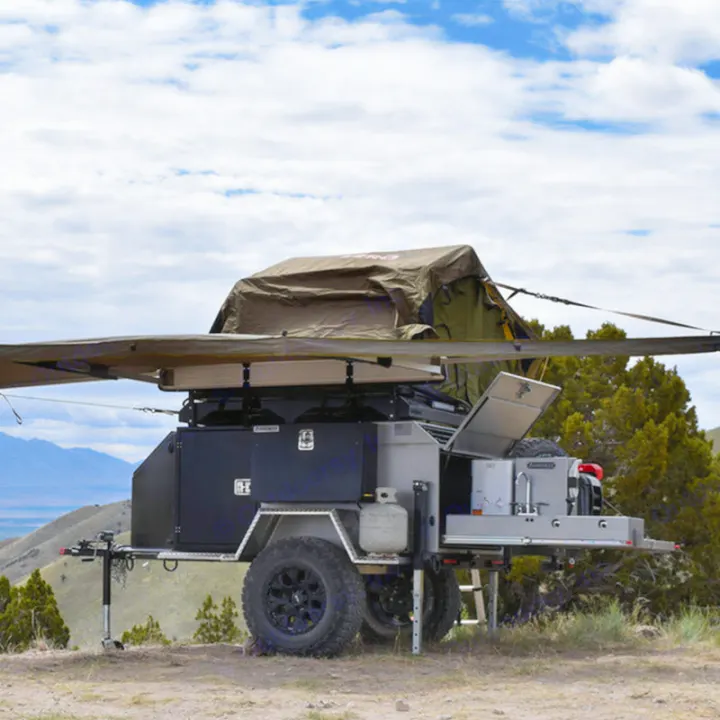 This off-road camping trailer, available for RV rental, offers a rooftop tent, awning, and outdoor kitchen setup.. Vorsheer Vorsheer Trailer 2022