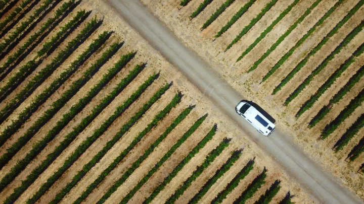 Drone view: An RV rental navigates a dirt road through a vibrant vineyard.. Winnebago Winnebago 2023