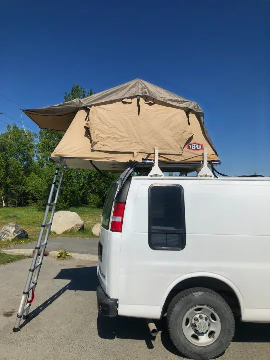 White RV rental van with a beige rooftop tent deployed, ladder extended. Perfect for van life and camping adventures.. Chevrolet Other 2006