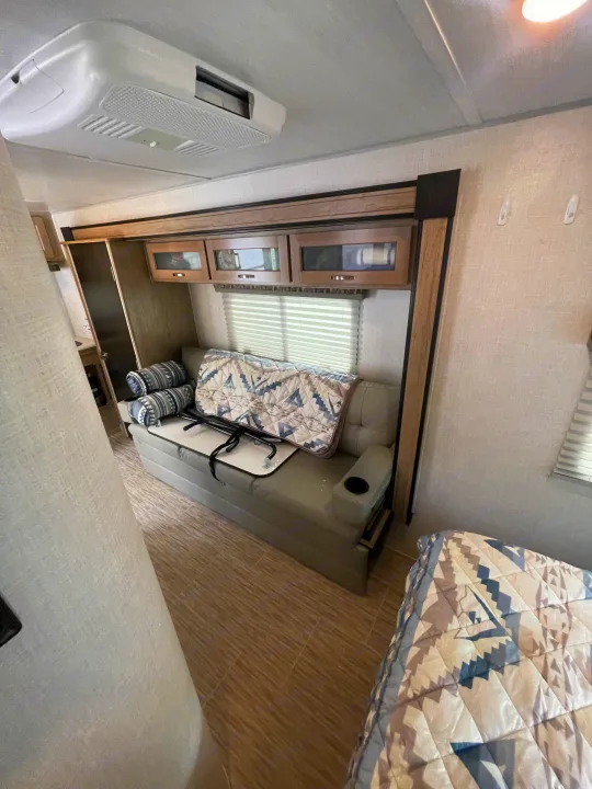 RV rental interior: A bright living area with a convertible sofa-bed, patterns, overhead storage, and ceiling AC.. R-Pod Hood River Edition 2020