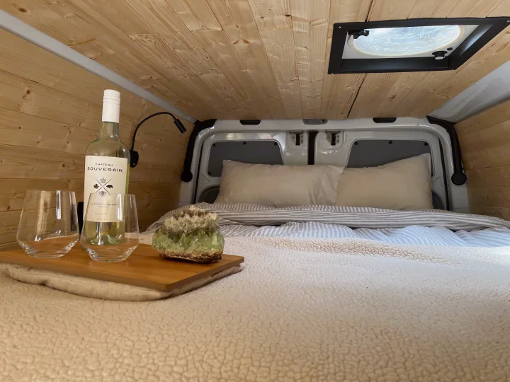 Enjoy a relaxing evening in this cozy RV rental. Features a comfy bed, wood walls, wine, and crystal decor.. Freightliner Sprinter 2010