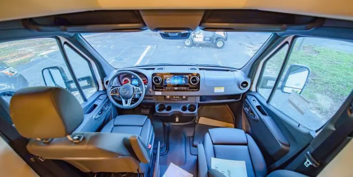 Modern Mercedes Sprinter RV rental interior: spacious cockpit with large screen dashboard & front view.. Tiffin Motorhomes Wayfarer LW 2023