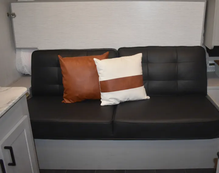 Modern black sofa with tan & white pillows inside this comfortable RV rental.. Heartland RVs Mallard 2022