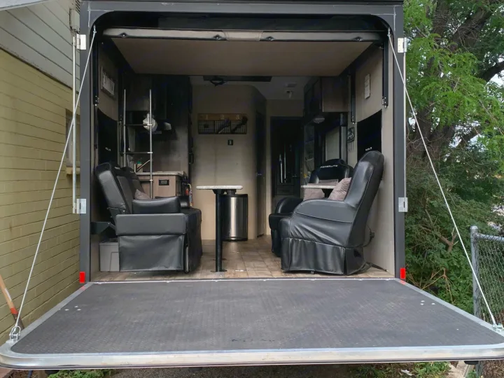 Inside this RV rental: a spacious toy hauler with an open ramp deck, showcasing comfortable seating and living space.. Pacific Coachworks Blaze'N 2017