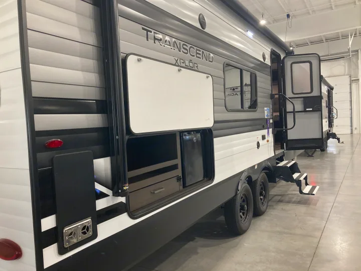 Side view of a Transcend XPLOR rv rental, featuring an outdoor kitchen, open entry with steps, and modern exterior.. Grand Design Transcend Xplor 2022