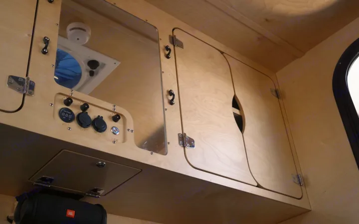 RV rental interior: overhead light wood cabinets, a power control panel (volts, USB, 12V), a ceiling vent, and a smoke detector.. Oregon Trail'R TerraDrop ALPHA 2022