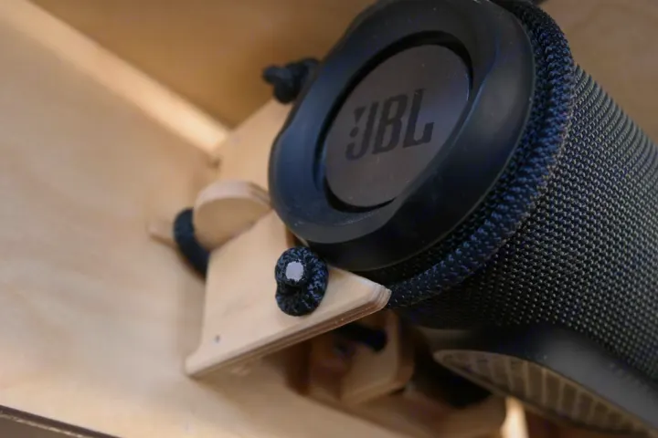 Close-up of a JBL portable speaker held by a custom wooden mount, perfect for an RV rental's audio system.. Oregon Trail'R TerraDrop ALPHA 2022