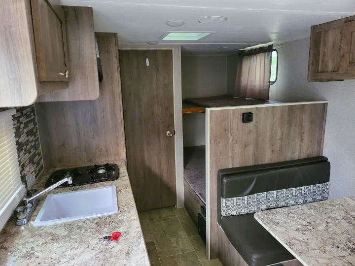 Spacious RV rental interior featuring a modern kitchen, cozy dinette, and comfortable bunk beds for family trips.. Aspen Trail LE 2020