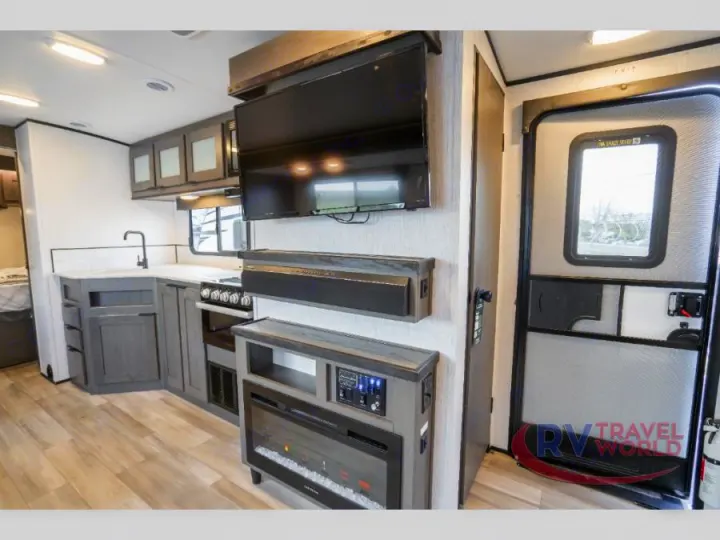 Step inside this RV rental's modern interior: a spacious kitchen, entertainment system with TV, fireplace, and entry door.. Cruiser RV MPG Ultra Lite 2022