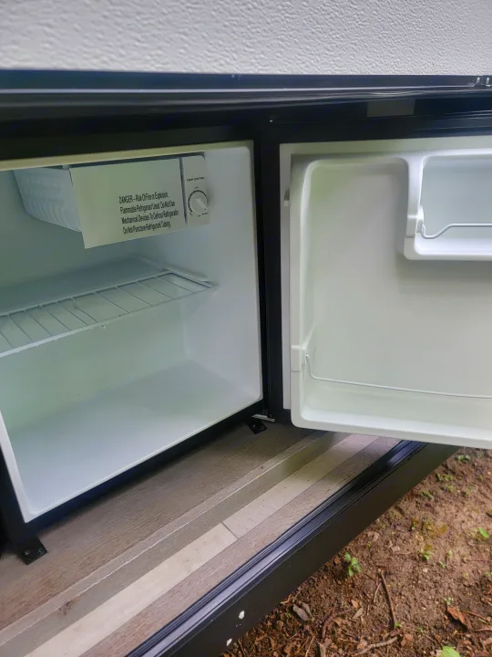 Inside an RV rental, this empty mini-fridge with freezer is ready for your adventure's provisions.. Keystone RV Springdale 2021