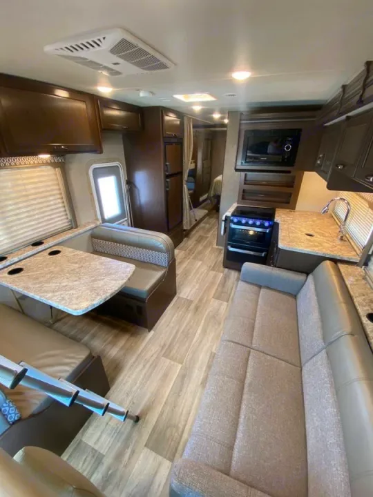 Inside this **rv rental**: a cozy living area with sofa, dinette, and functional kitchen, perfect for your next adventure.. Thor Freedom Elite 2020