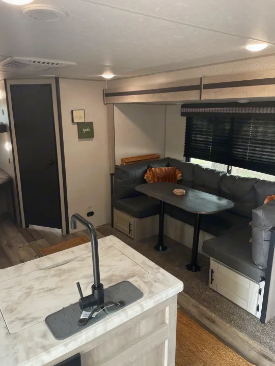 Spacious RV rental interior showcasing a modern kitchen counter and comfortable U-shaped dining booth.. Connect SE 2021