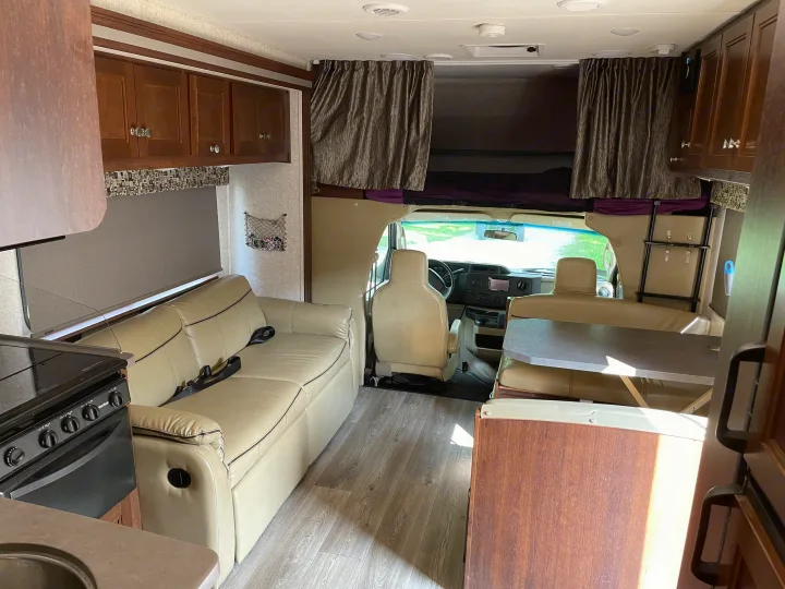An inviting rv rental interior with a light-filled living room, full kitchen, dining area, and front cab-over bunk.. Forest River Sunseeker 2017