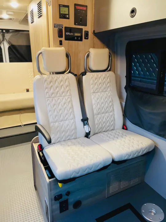 Clean RV rental interior featuring comfortable white quilted seats and essential control panels for a great road trip.. Winnebago Winnebago 2023