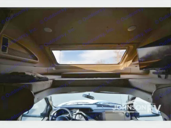Spacious RV rental interior with a comfy cab-over bunk bed, large skylight, and front cabin view. Perfect for travel!. Entegra Coach Odyssey 2019