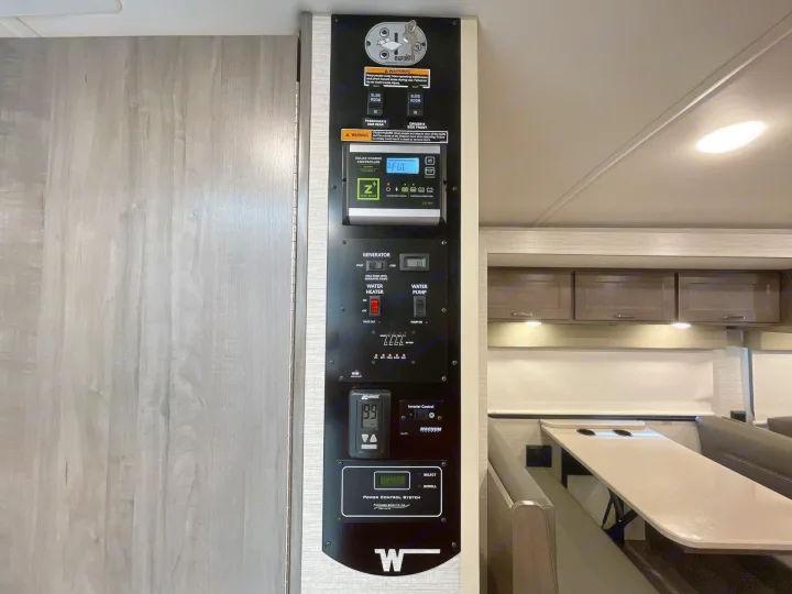 An RV rental's central control panel, managing slide-outs, solar charging, generator, water heater, and tank levels.. Winnebago Sunstar 2022