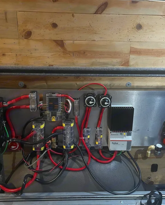 RV rental power hub: complex electrical wiring, fuses, battery switches, and a TriStar solar charge controller visible.. Freightliner Sprinter 2015