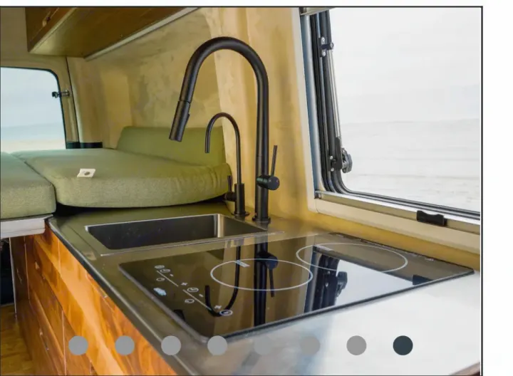 RV rental: Modern camper kitchen with sink, induction cooktop, green bed, and window offering a bright beach view.. Mercedes-Benz Sprinter “144” 2020