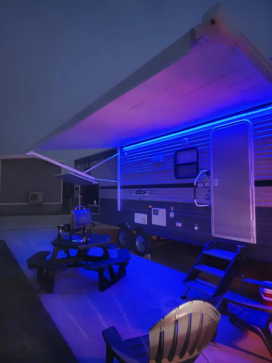 Vibrant blue and pink LED lights illuminate this Shasta RV at night, perfect for an RV rental adventure.. Forest River Shasta 2019