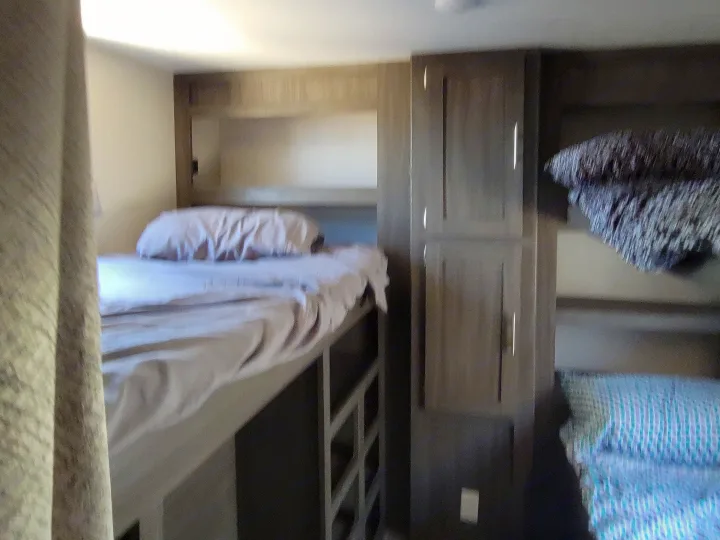 Comfortable bunk beds with integrated storage in this RV rental's compact sleeping area.. Forest River Shasta 2019