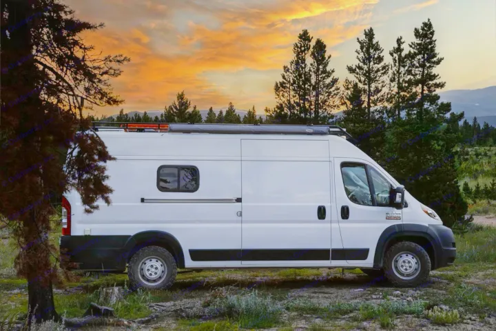 A white camper van, equipped with an awning, rests under a vibrant sunset sky, surrounded by trees. Ideal RV rental.. Other Other 2021