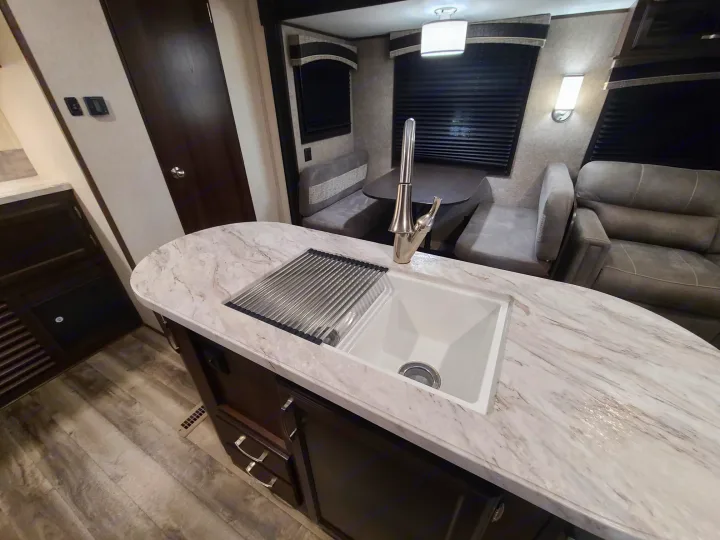 Modern RV rental interior: kitchen island with sink, dining booth, and cozy living area perfect for travel.. Jayco Jay Flight 2020