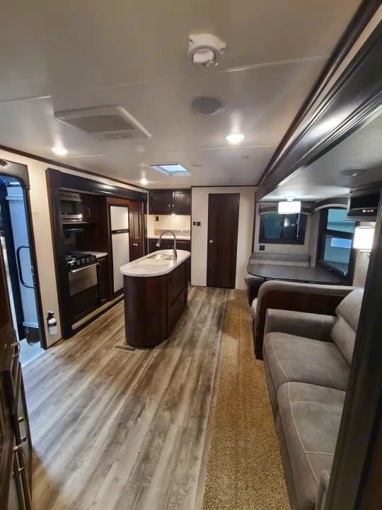 Spacious rv rental interior showing kitchen island, dining area, and living room with a sofa. Perfect for travel.. Jayco Jay Flight 2020