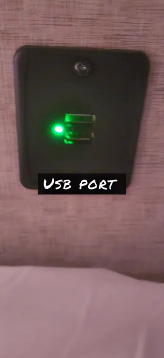 Close-up: An RV rental's USB charging port with a green LED, ready to power devices.. Forest River Cherokee Grey Wolf 2018