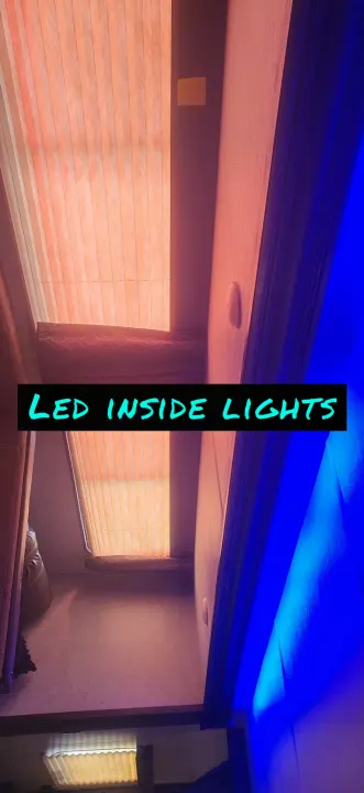 **RV rental interior** with vibrant LED ambiance. Pleated blinds let in natural light, complemented by a cool blue glow.. Forest River Cherokee Grey Wolf 2018