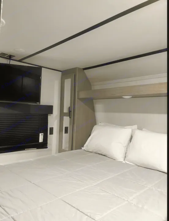 Comfortable RV rental bedroom with a cozy bed, TV, and storage. Perfect for your next adventure.. Keystone RV Hideout 2020