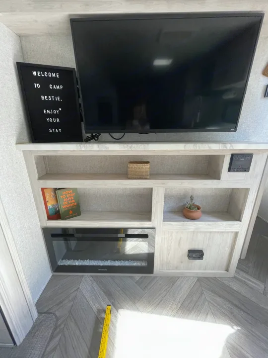 Explore this well-equipped RV rental! Features include a Vizio TV, built-in shelving, cozy fireplace, and welcome sign.. East to West Other 2022