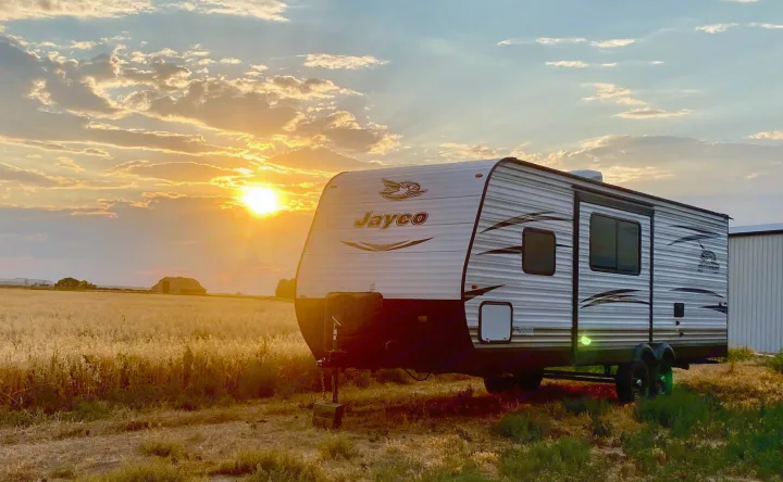 Golden sunset over a Jayco RV parked in a field. Ideal for an RV rental road trip or serene camp.. Jayco Jay Flight SLX 2018