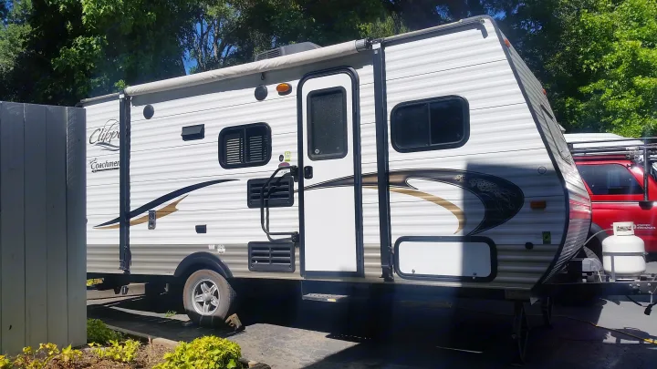 RV rental: A white Coachmen Clipper travel trailer, hitched to a red truck, stands ready for camping adventures.. Clipper Clipper Trailer 2015