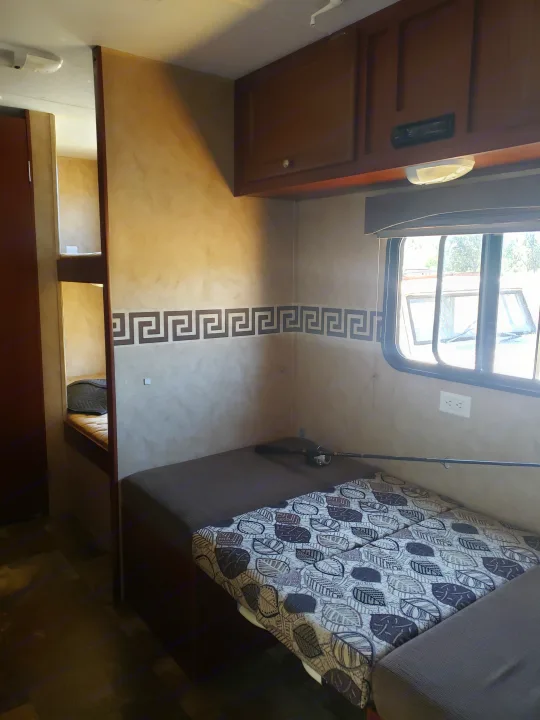 Cozy RV rental bedroom featuring a patterned bedspread, bunk beds, and decorative walls, ideal for travel.. Clipper Clipper Trailer 2015