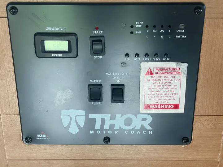 RV rental control panel: generator (286.8 hrs), water pump, water heater, tank/battery levels, and CO warning label.. Thor Four Winds 2021