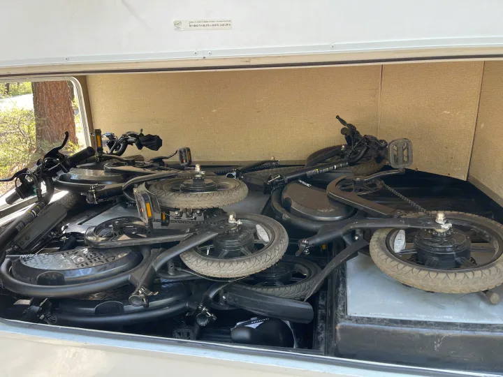 This RV rental's storage compartment is packed with multiple folded Jetson e-bikes, perfect for compact travel adventures.. Thor Four Winds 2019