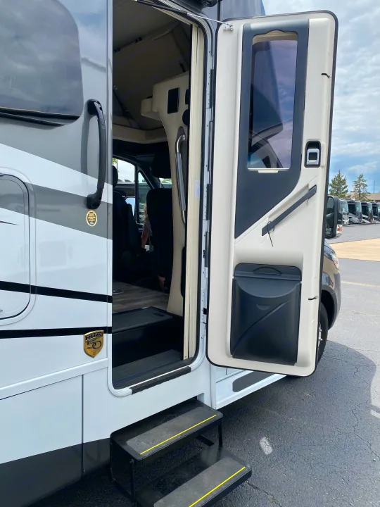 Open side door of a motorhome, revealing its interior and entry steps, ideal for your next RV rental adventure.. Tiffin Motorhomes Wayfarer LW 2023