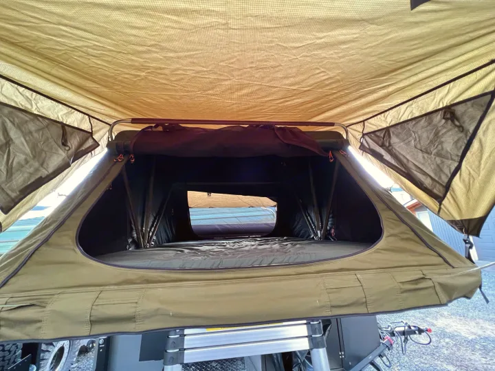 Inside a spacious olive-green rooftop tent, showing the mattress and open windows. Perfect for an RV rental camping adventure.. Vorsheer Vorsheer Trailer 2022