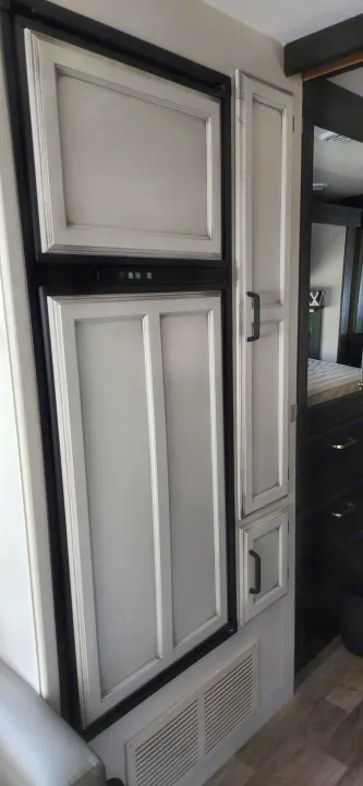 RV rental: Light gray paneled RV fridge/freezer unit with black handles & upper cabinets, plus air vents.. Jayco Alante 2021