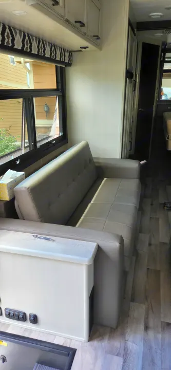 Cozy RV rental interior featuring a light-colored sofa, cabinets, and wood-look flooring, creating a comfortable living space.. Jayco Alante 2021