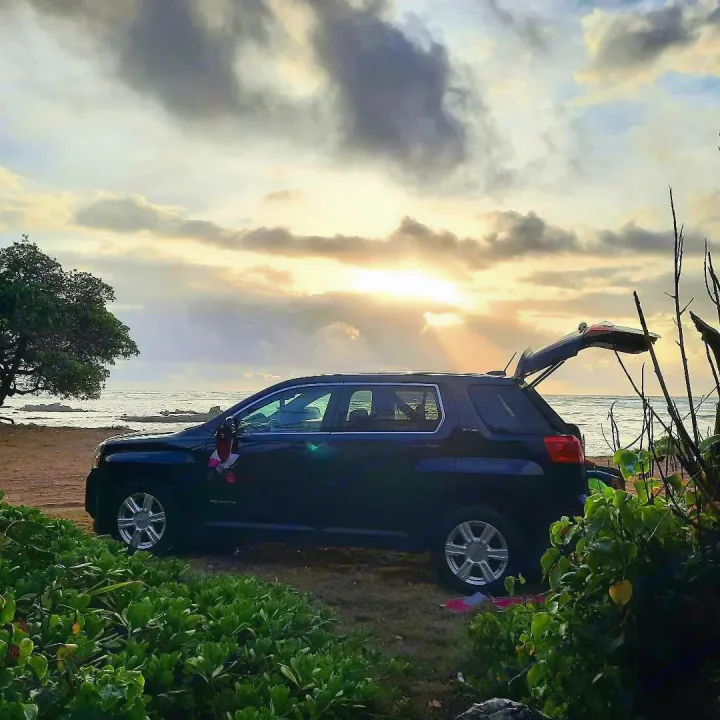 Your next RV rental adventure starts here! Dark SUV parked beachside at sunset, trunk open, ready for travel.. Gmc Terrain 2015