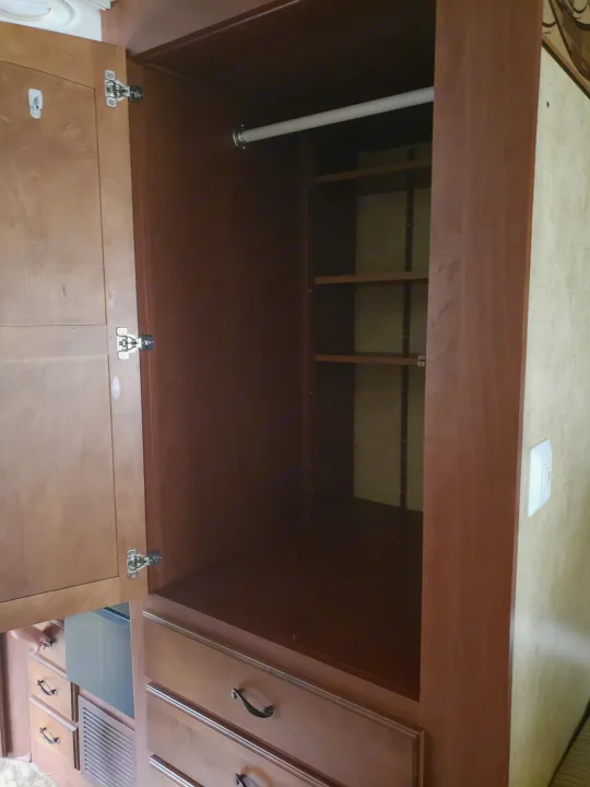 RV rental closet interior with a hanging rod, adjustable shelves, and bottom drawers, offering efficient storage within a compact space.. Jayco Greyhawk 2011