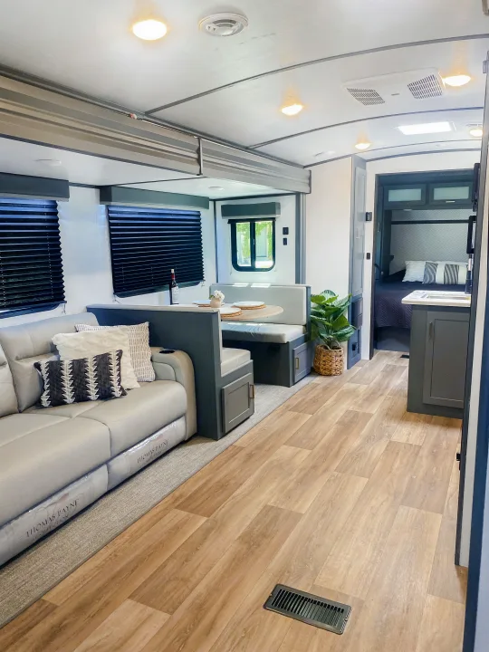 Modern RV rental interior with a spacious living area, dinette, kitchen, and private bedroom.. Keystone RV Bullet Ultra Lite 2022