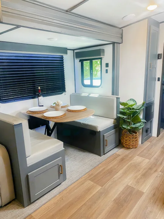 RV rental interior: cozy dinette area with modern gray & white decor, perfect for your next road trip.. Keystone RV Bullet Ultra Lite 2022