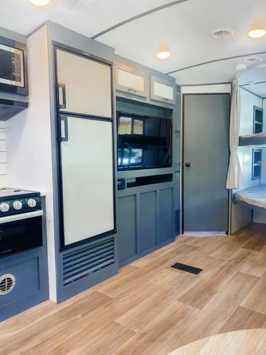 Modern RV rental interior with kitchen, bunk beds, and entertainment unit. Perfect for family adventures!. Keystone RV Bullet Ultra Lite 2022