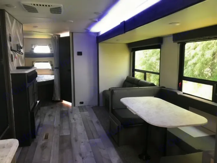 Step inside this inviting rv rental, showcasing a modern dinette, bunk beds, and bright living area.. KZ Sportsmen LE 2021