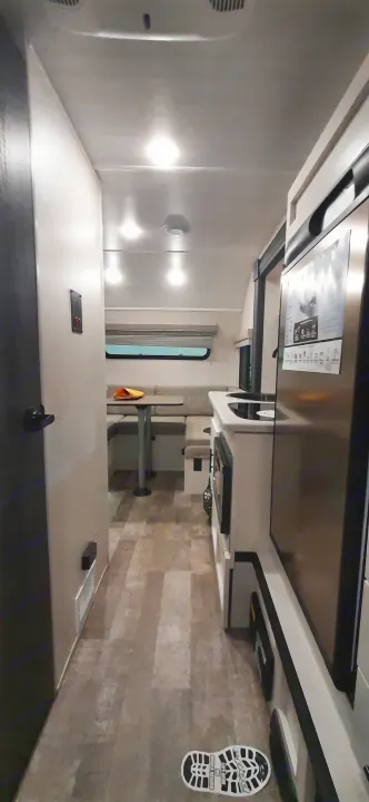 This RV rental's interior features a modern kitchen, dining area, and wood-look floor, ideal for travel adventures.. Forest River RPOD 190 2021