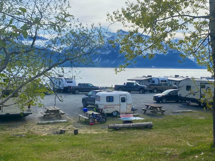 Scenic RV rental campground with various campers, featuring stunning mountain and waterfront views. Ideal for outdoor adventures.. Scamp 13' 1987