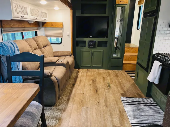 RV rental: Spacious interior with a cozy living area, brown sofa, wood-look floors, green built-ins, and a glimpse of the kitchen.. Heartland RVs Greystone 2012