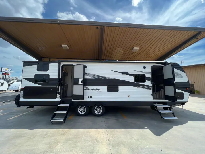 Spacious RV rental: A sleek black and white travel trailer with open doors and steps, ready for your next adventure.. Dream 290DBS 2022